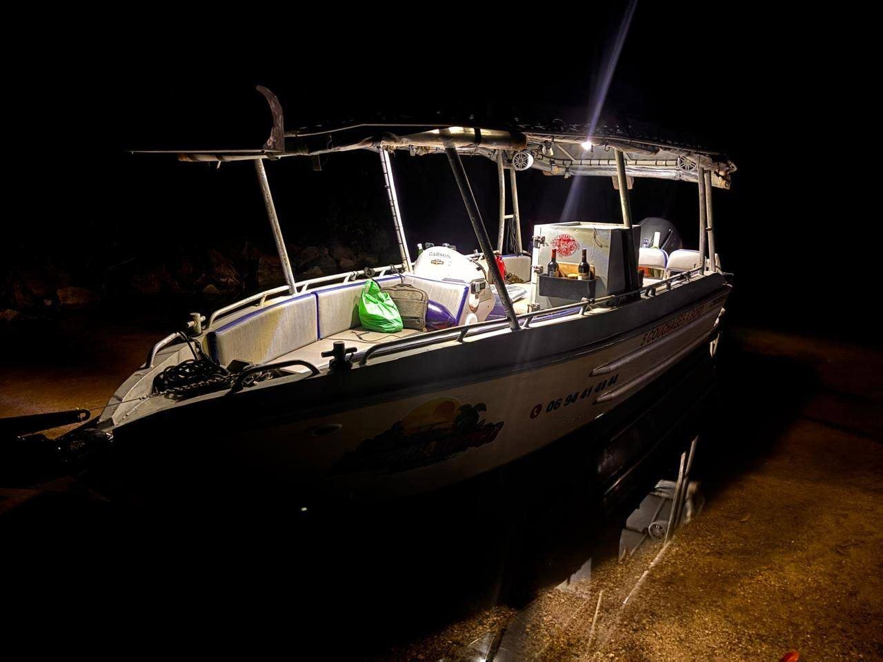 Le LIBERTAAA éclairé de nuit, échoué sur un banc de sable